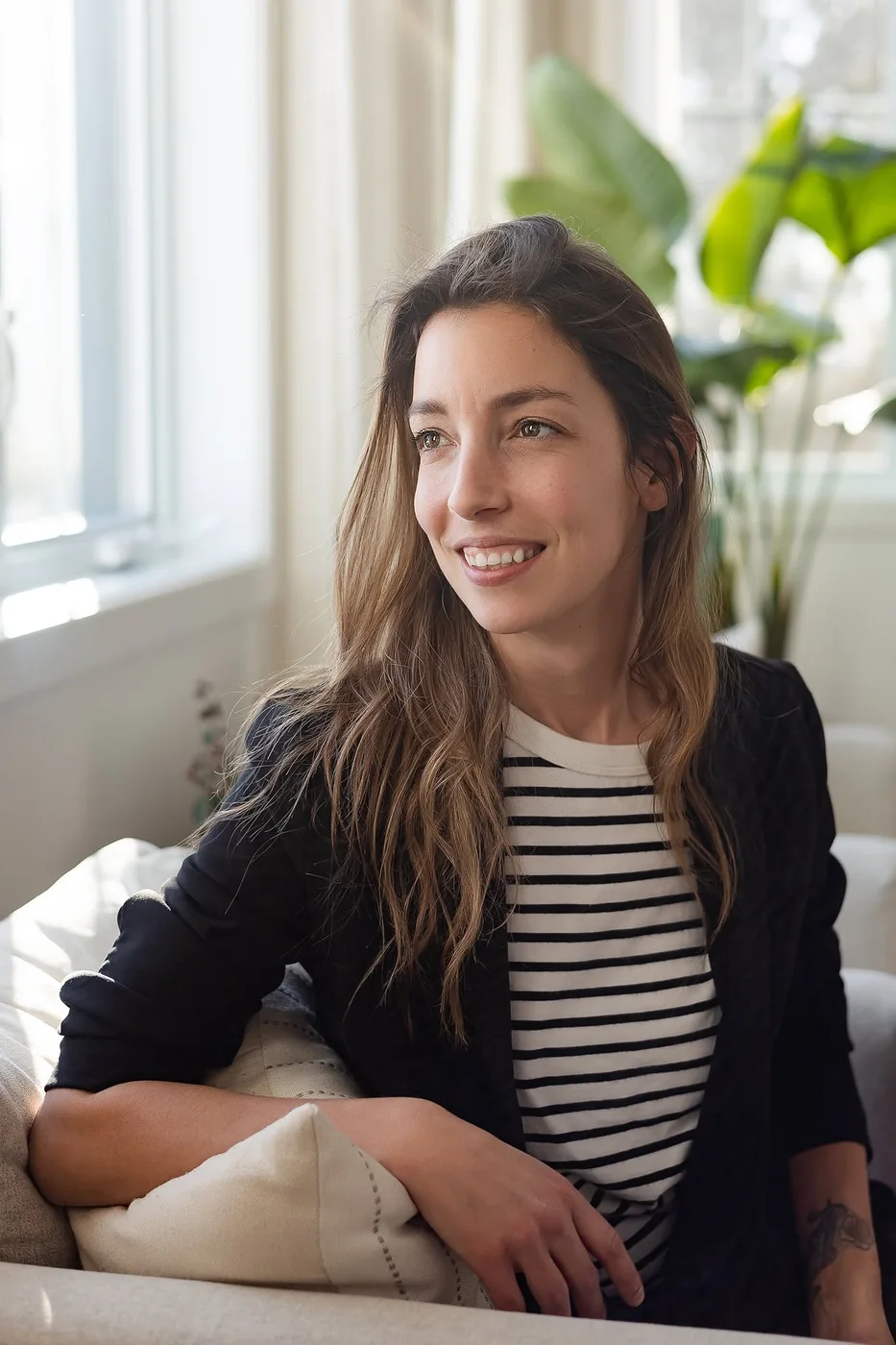 Laura Vandal sourit, assise près d’une fenêtre lumineuse