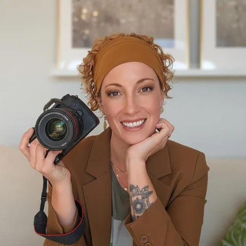 Rébecca Vandal, photographe, sourit avec son appareil photo à la main